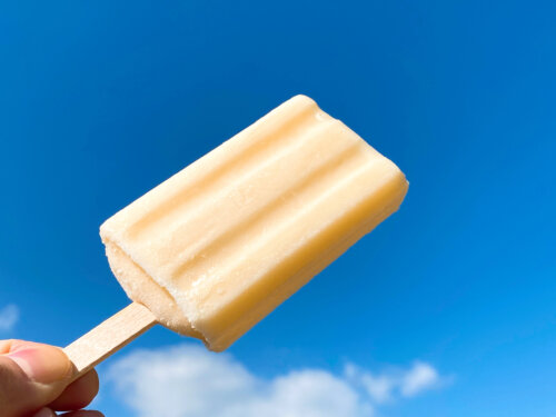 『アイスキャンディー』を手に持って青空に掲げた写真