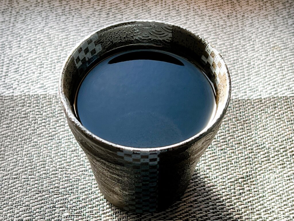 黒い陶器のカップに入った「冷や」の写真